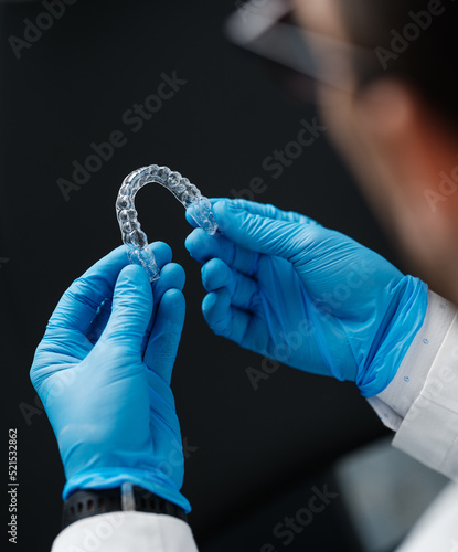 Invisible orthodontics cosmetic aligners in hands of doctor