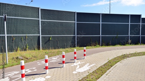 Reducing of noise and sound pollution made by transportation. Narrow road and acoustical barrier. photo
