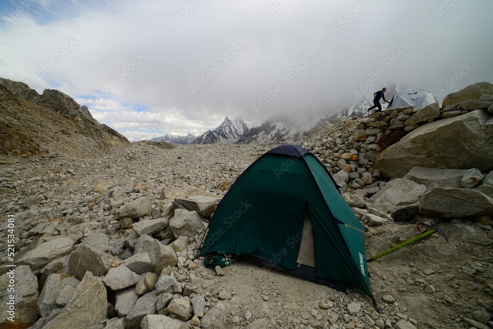 A foreign climber runs towards his tent for shelter as the storm approaches his campsite on the brink of Biafo Glacier, Pakistan.