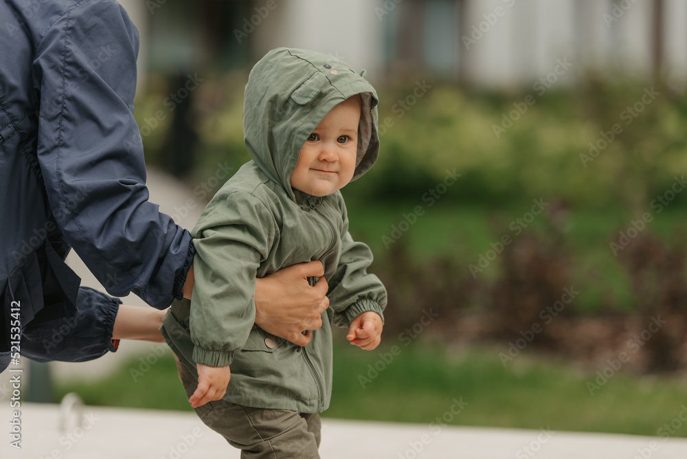 A mom is teaching her female toddler how to do steps in the street at noon. A mom is teaching her female toddler how to do steps in the street at noon.