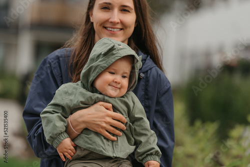 Obraz na płótnie A happy mother is holding her young daughter on a cloudy day. w salonie