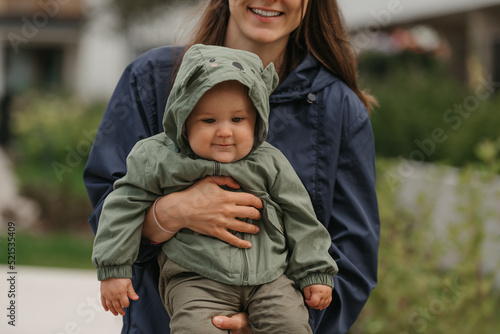 Obraz na płótnie A happy mother is holding her young daughter on a cloudy day. w salonie
