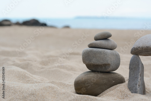 Stacks of stones on beautiful sandy beach near sea  space for text