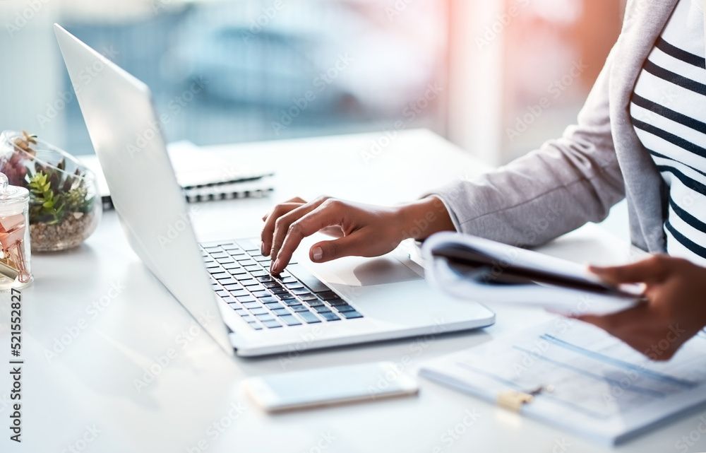 Hands of a female entrepreneur sending emails and doing research on the internet. Businesswoman, secretary and data professional typing on a laptop while analyzing financial reports in her office. Hands of a female entrepreneur sending emails and doing research on the internet. Businesswoman, secretary and data professional typing on a laptop while analyzing financial reports in her office.