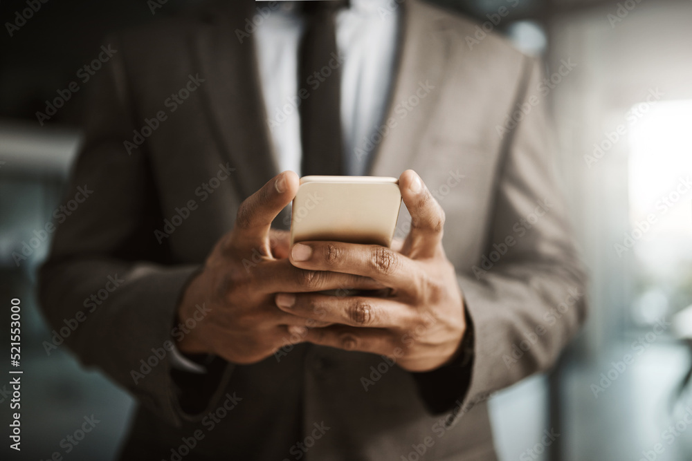 Businessman texting on a phone to send a formal business sms text inside an office at work. African corporate executive professional male wearing a suit typing an email to his client online close up Businessman texting on a phone to send a formal business sms text inside an office at work. African corporate executive professional male wearing a suit typing an email to his client online close up