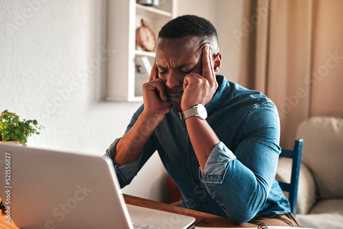 Stress, pain and headache while working remote on laptop from home office, freelance man annoyed and under pressure. Frustrated male suffering from a migraine, pressure from workload or a deadline