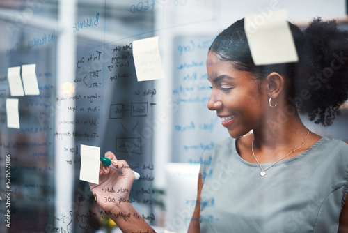 Fototapeta Happy, inspired and confident business woman brainstorming ideas, writing on transparent glass board with sticky notes