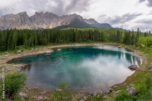 Beautiful view of Lake Carezza, a small mountain alpine lake is famous tourist destinations for calm waters and dark green color in the Dolomites in South Tyrol at Italy.