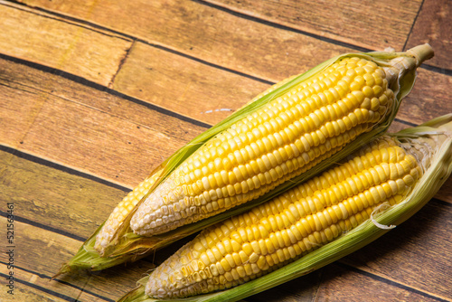 Corn on the wooden floor An ear of corn isolated on a white background Export products Processed