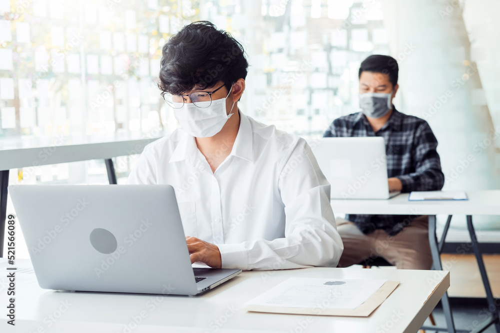 Business people with protective face masks are working in the office keeping a distance during COVID-19 pandemic . social distancing concept. Business people with protective face masks are working in the office keeping a distance during COVID-19 pandemic . social distancing concept.
