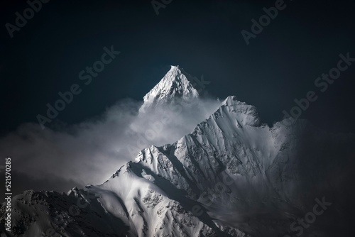Photography High-angle shot of snowy mountains covered with clouds during a dark evening