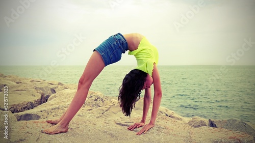 Fotografia slender girl on the rocks with old toned effet