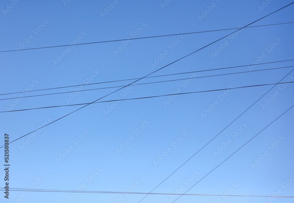 Electric wires against the blue sky. Background Electric wires against the blue sky. Background