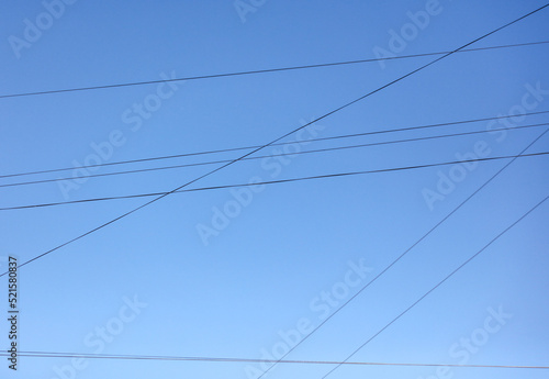 Electric wires against the blue sky. Background