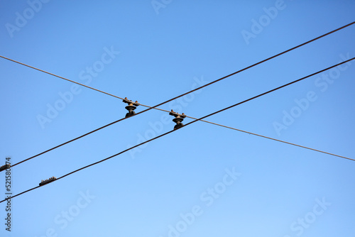 Trolley bus wires against the blue sky
