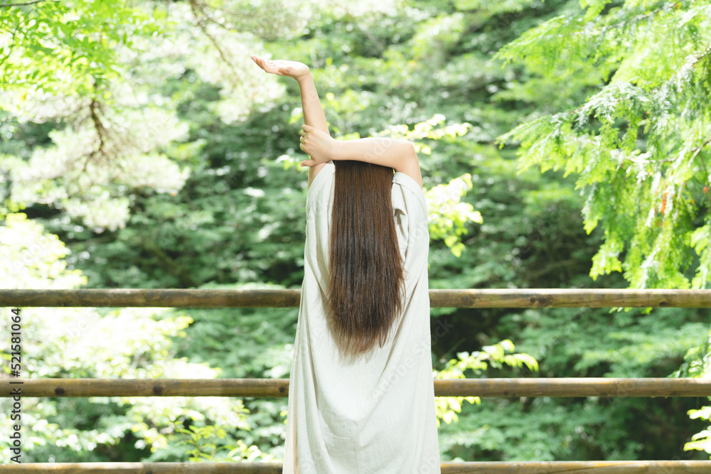 Naklejka premium 森の中でストレッチする女性 