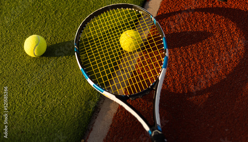 tennis balls and racket on the green grass background