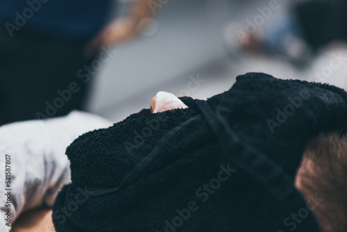 Barbershop customer with warm towel on the face