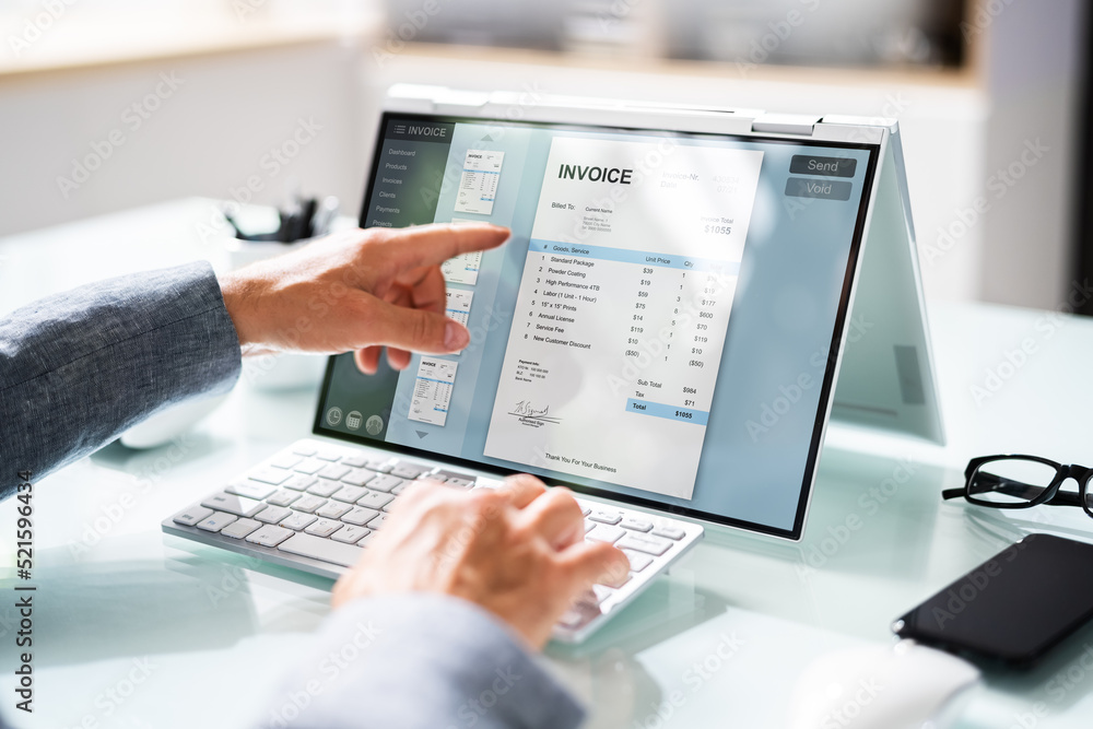 Businessperson Analyzing Invoice On Laptop Businessperson Analyzing Invoice On Laptop