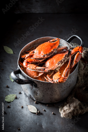 Ingredients for fresh red crabs in old rustic metal pot.