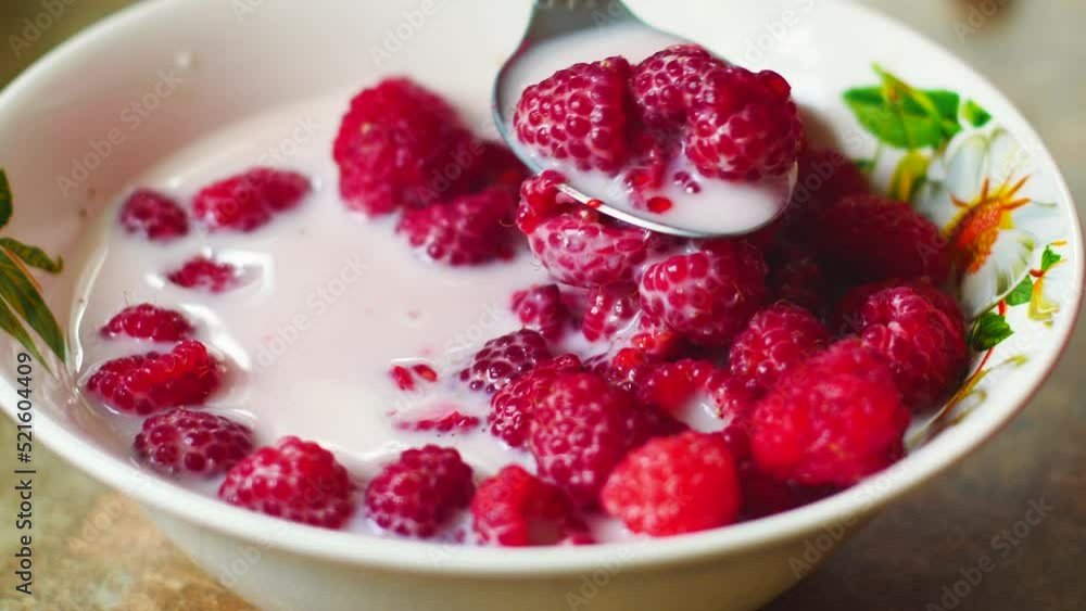 close-up juicy ripe raspberries in milk mix eat with a spoon from a plate. selective focus.Breakfast of berries and milk.Raspberries. Useful properties of the berry. Red appetizing raspberry close-up juicy ripe raspberries in milk mix eat with a spoon from a plate. selective focus.Breakfast of berries and milk.Raspberries. Useful properties of the berry. Red appetizing raspberry