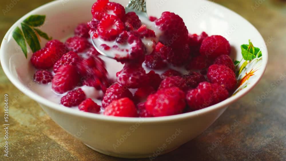 close-up appetizing raspberries in milk from a plate eaten with a spoon, selective focus. Mix of raspberries and milk, healthy breakfast of fresh berries. Healthy food concept. raspberry vitamins. close-up appetizing raspberries in milk from a plate eaten with a spoon, selective focus. Mix of raspberries and milk, healthy breakfast of fresh berries. Healthy food concept. raspberry vitamins.