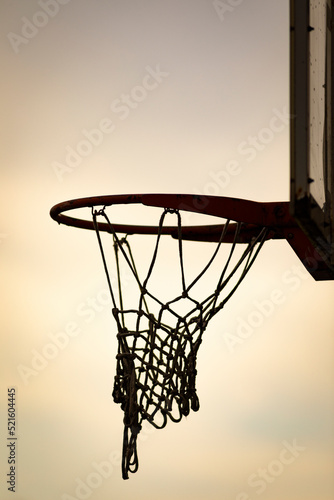 Silueta de una canasta de baloncesto (basket, basketball) durante un atardecer de verano (outdoor al aire libre)