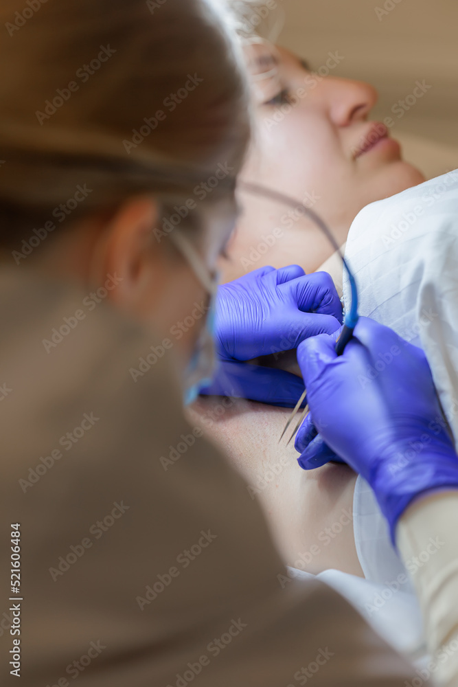 in the cosmetology room, the doctor bent over the model and perform the