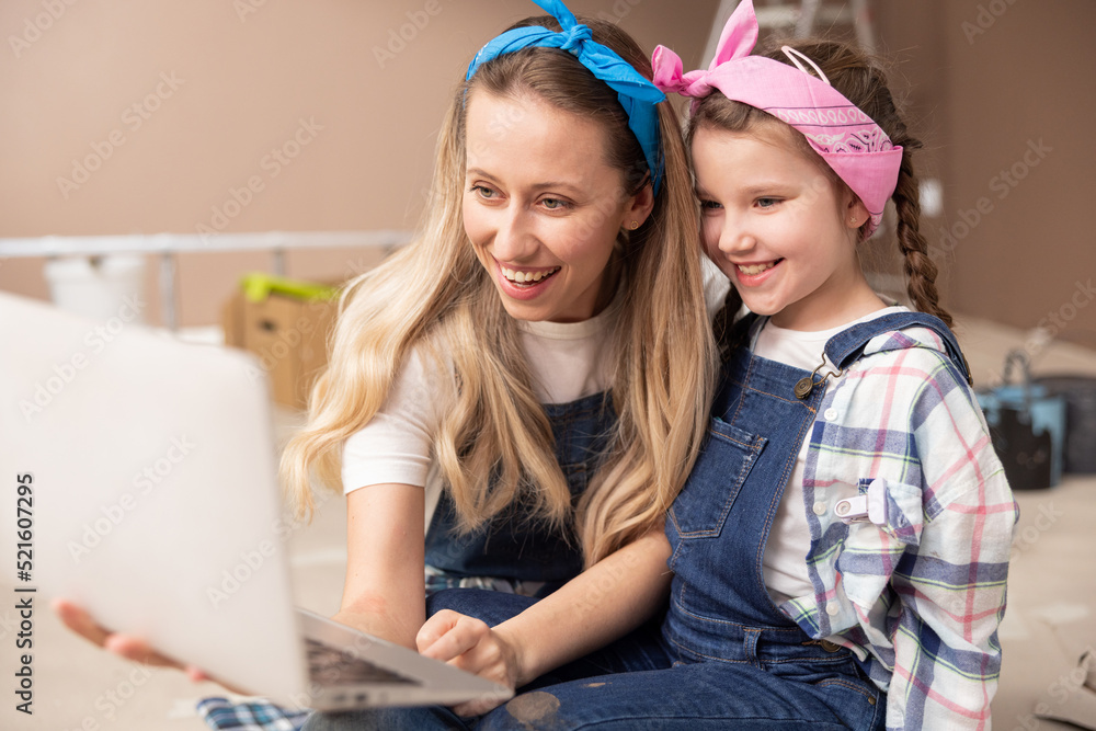 A girl and mother browse through offers in an online store on a laptop, order furniture with home delivery, redecorate an apartment, choose room inspirations. A girl and mother browse through offers in an online store on a laptop, order furniture with home delivery, redecorate an apartment, choose room inspirations.
