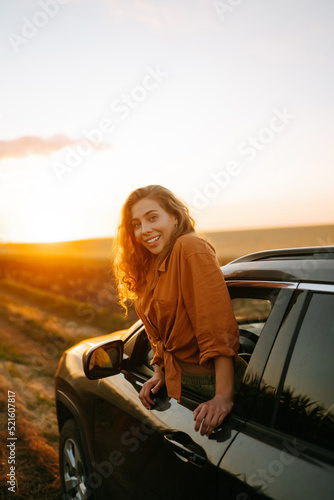 Towards adventure! Young woman is resting and enjoying the trip in the car.  Lifestyle, travel, tourism, nature, active life. © maxbelchenko