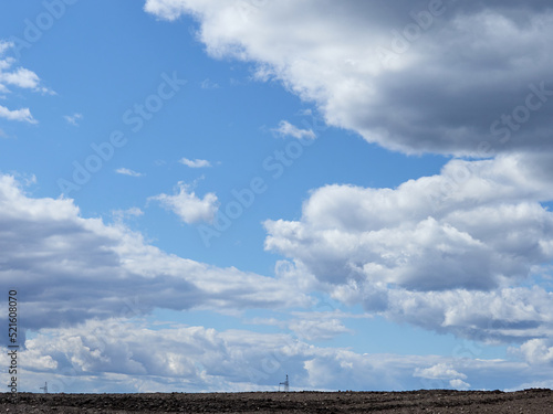 Cumulus clouds and field. Horizon and sky with field