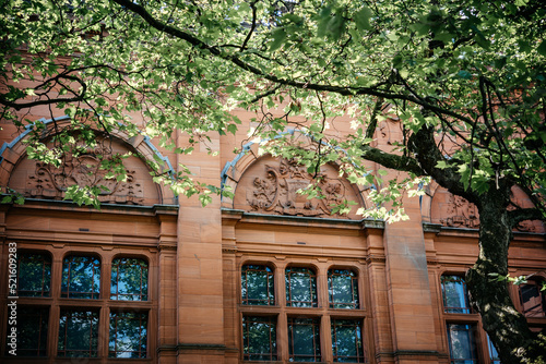 Beautiful architecture of Kelvingrove Museum in the shade of old tree foliage in Glasgow Scotland photo