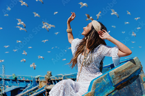 Happy girl looks at the sky and flying seagulls. Essaouira. Morocco