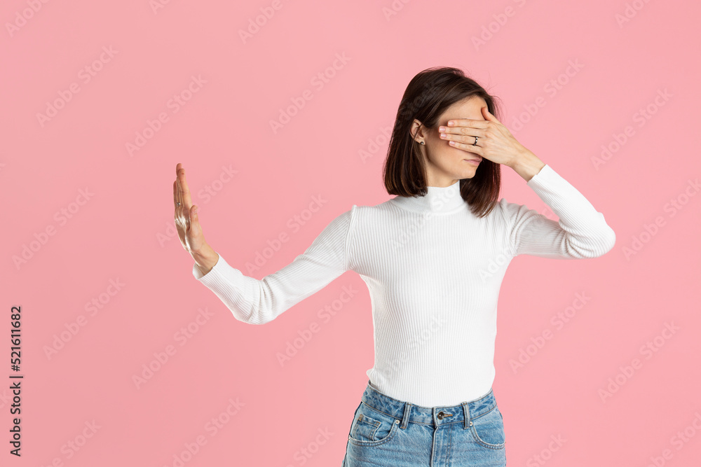 Beautiful girl closes her eyes and looks away on a pink background Beautiful girl closes her eyes and looks away on a pink background