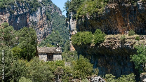 stone building with pitched roof in a large canyon gorge, the Anisclo Canyon, Ordesa National Park, Aragon Spain, blue sky