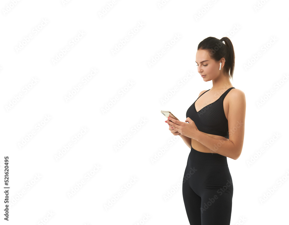 fitness girl on training in sportswear holds a smart phone in her hands fitness girl on training in sportswear holds a smart phone in her hands