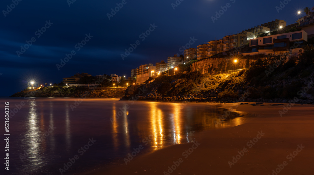Village of Cullera at night next to the beach with reflection in the water