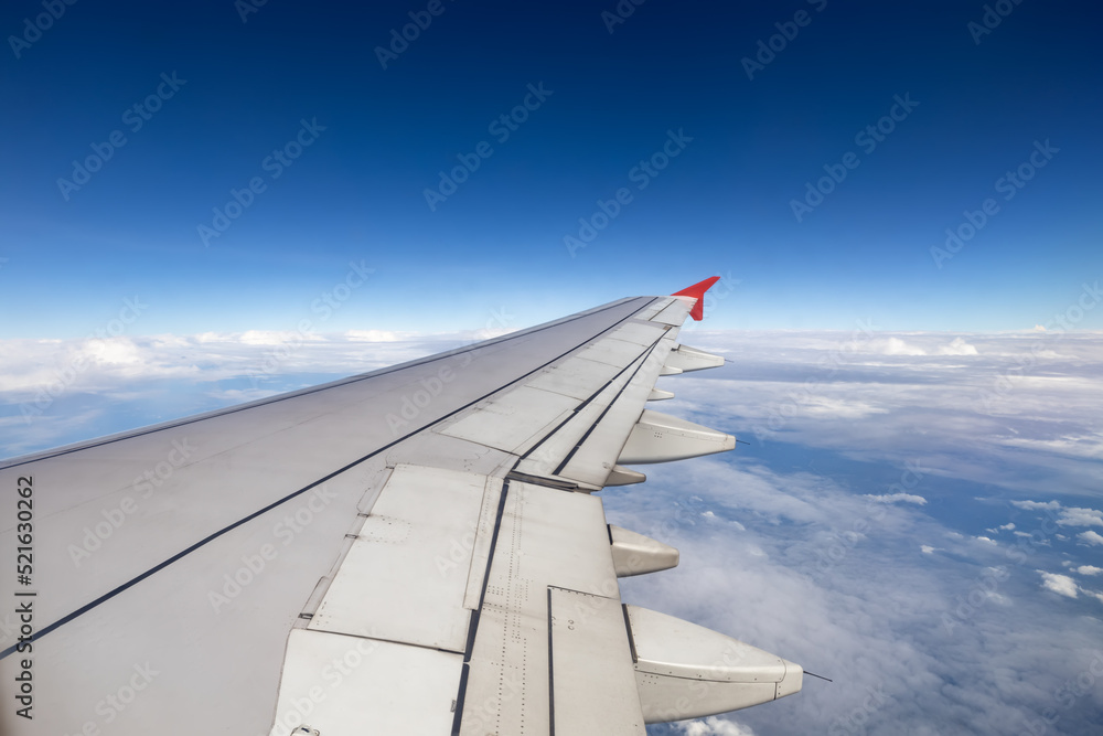 Obraz premium Wing of an airplane flying above the clouds.