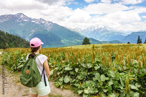 Svaneti landscape on a Summer day. Young tourist woman with a backpack overlooking Caucasus mountain range near Mestia photo