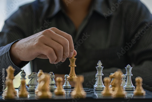 Close-up of confident businessman playing chess game to analyze development new strategic plan Leadership and Teamwork Ideas for Business Success