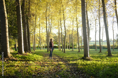 Teenage girl standing on a footpath in a forest glade, France