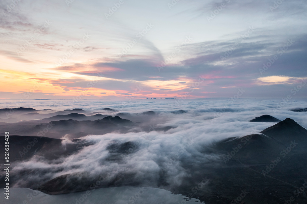 Aerial view of fog over the mountain peaks at sunset in Iceland. Aerial view of fog over the mountain peaks at sunset in Iceland.