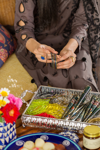 Women hands with bangles, henna and rings
