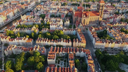 The camera flies over the center of a European city in the Netherlands. Aerial shot of red roof houses in the sunset light. High quality 4k footage