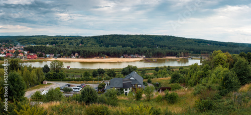 Panoramic view from the observation tower on the reservoir in Krasnobród. Hills covered with forest. Beach by the lagoon. Krasnobród, Poland