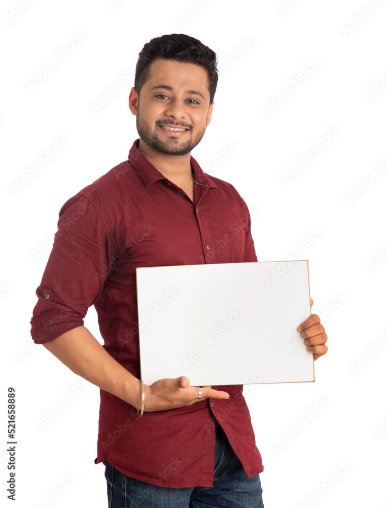 A happy young man holding and displaying a signboard or placard in his hands on a white background. A happy young man holding and displaying a signboard or placard in his hands on a white background.
