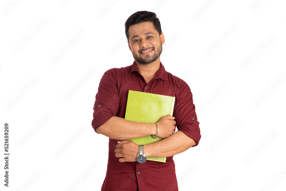 Young happy man holding and posing with the book on white background. Young happy man holding and posing with the book on white background.