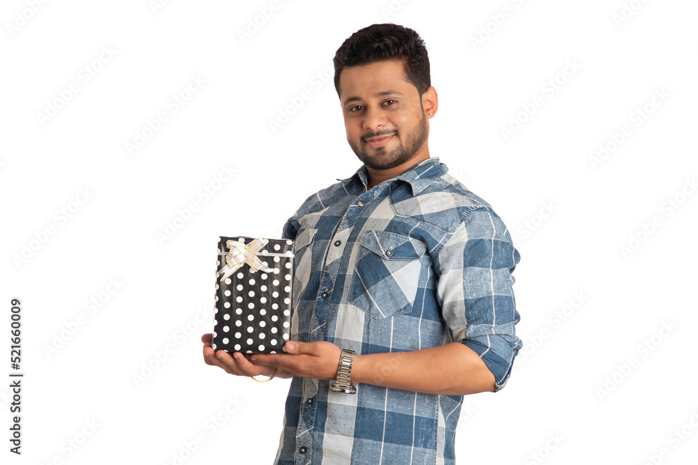 Portrait of young happy smiling handsome man holding gift box and posing on a white background. Portrait of young happy smiling handsome man holding gift box and posing on a white background.