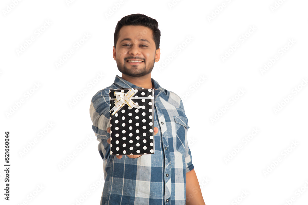 Portrait of young happy smiling handsome man holding gift box and posing on a white background. Portrait of young happy smiling handsome man holding gift box and posing on a white background.
