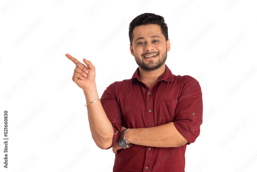 Portrait of a successful cheerful young man pointing and presenting something with hand or finger with a happy smiling face. Portrait of a successful cheerful young man pointing and presenting something with hand or finger with a happy smiling face.